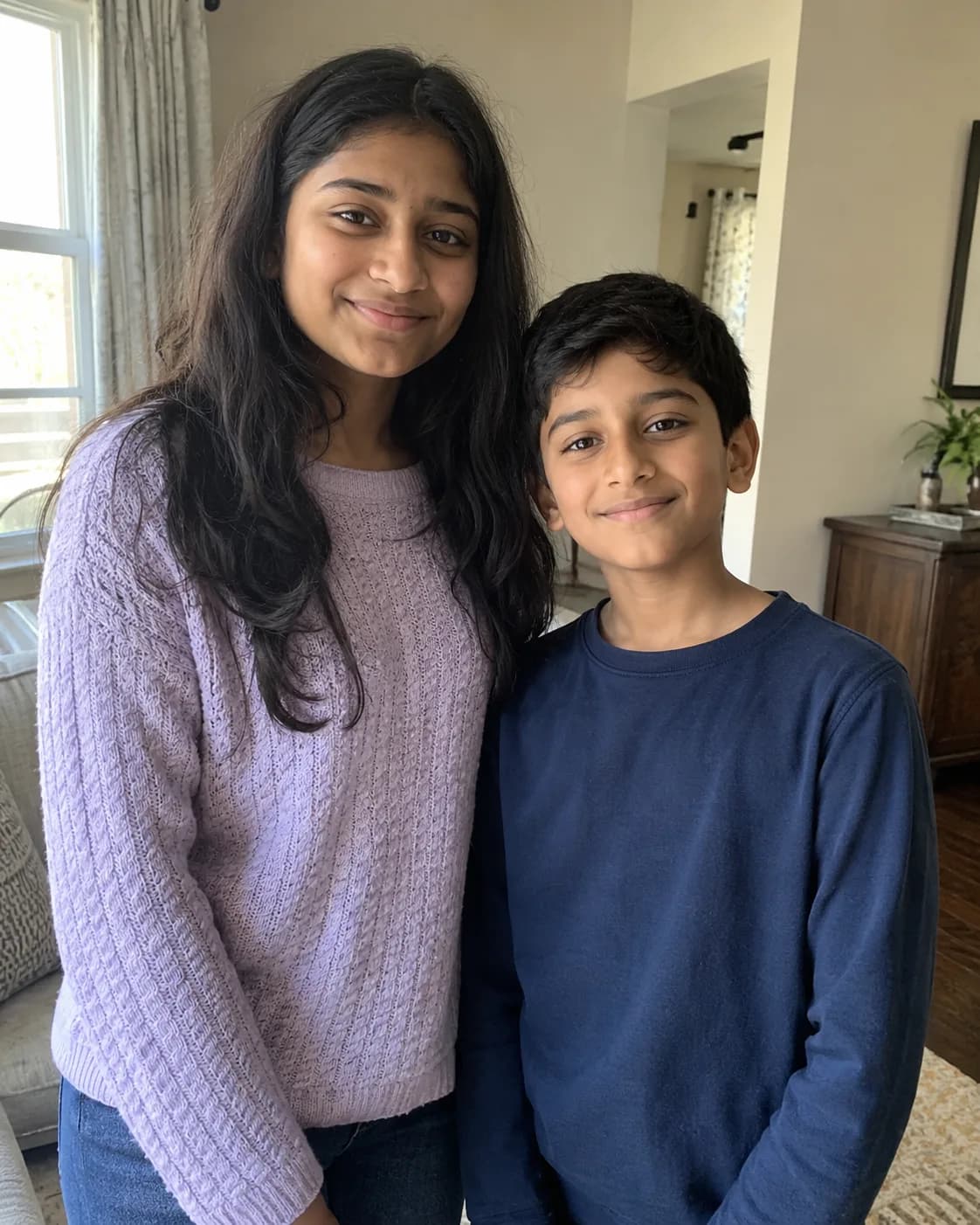 Two children, a girl in a lavender knit and a boy in a navy top.